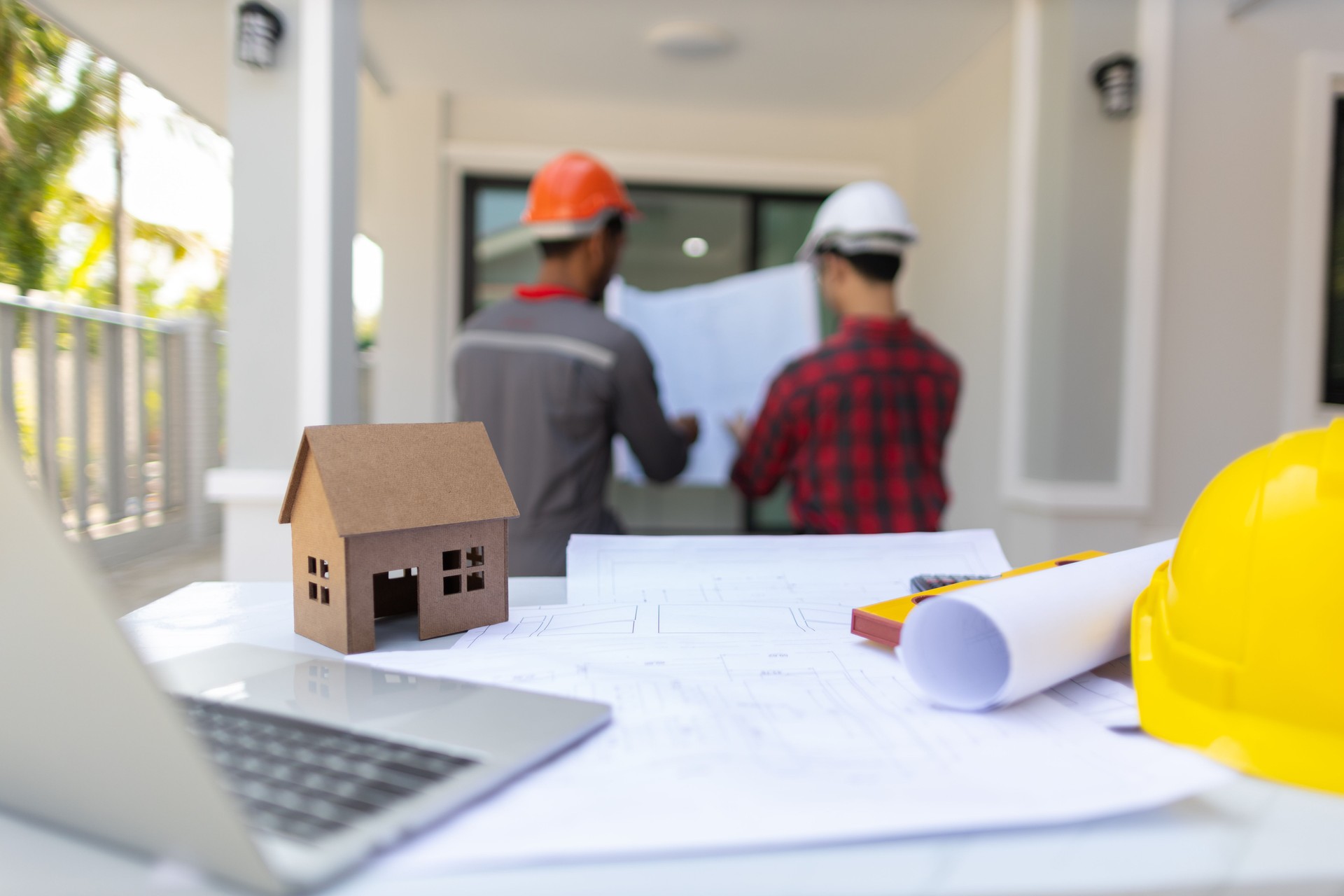 Contractor engineer discusses with an architect the construction of a home renovation project at the job site.